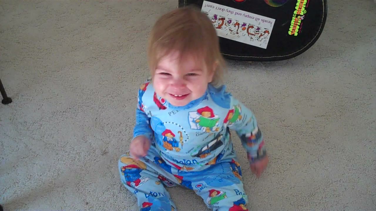 Julia as a toddler in Paddington Bear pajamas, mid-grin